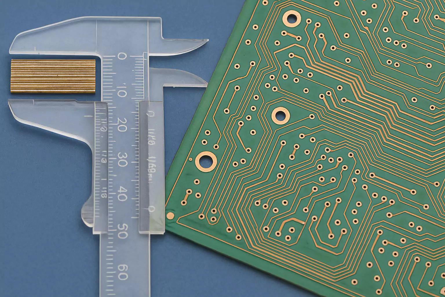 Close-up of PCB and caliper showing laminate layer inspection