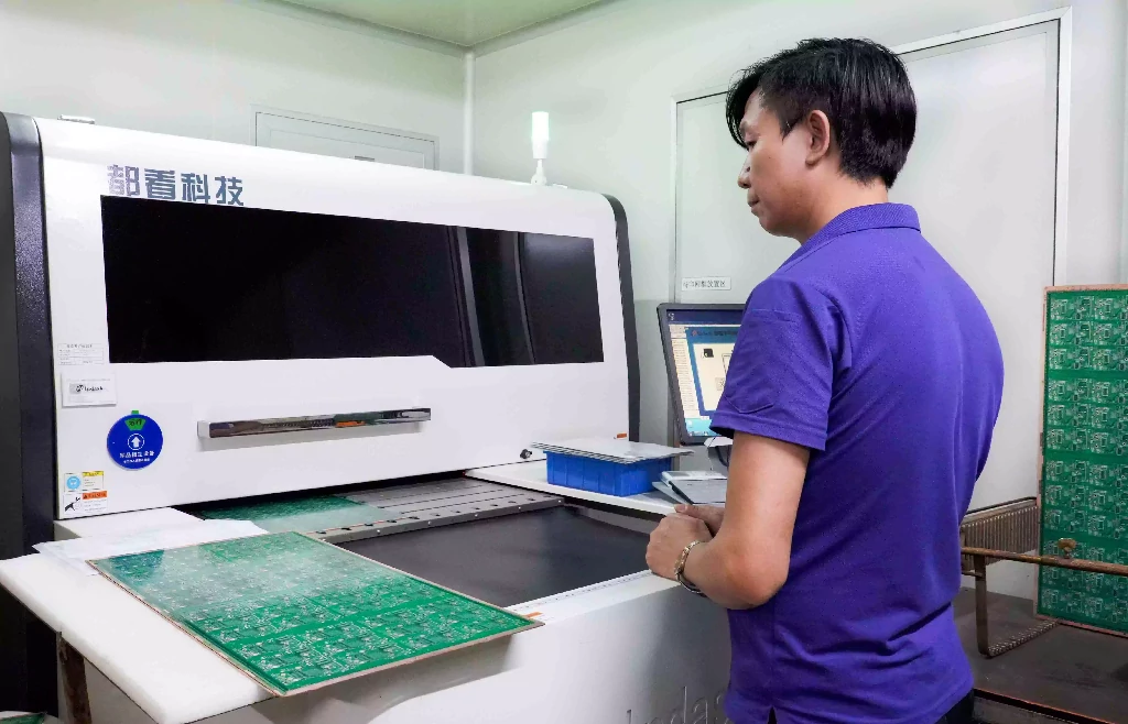 Operator checking PCB panels with an AOI system for silkscreen and solder mask alignment.