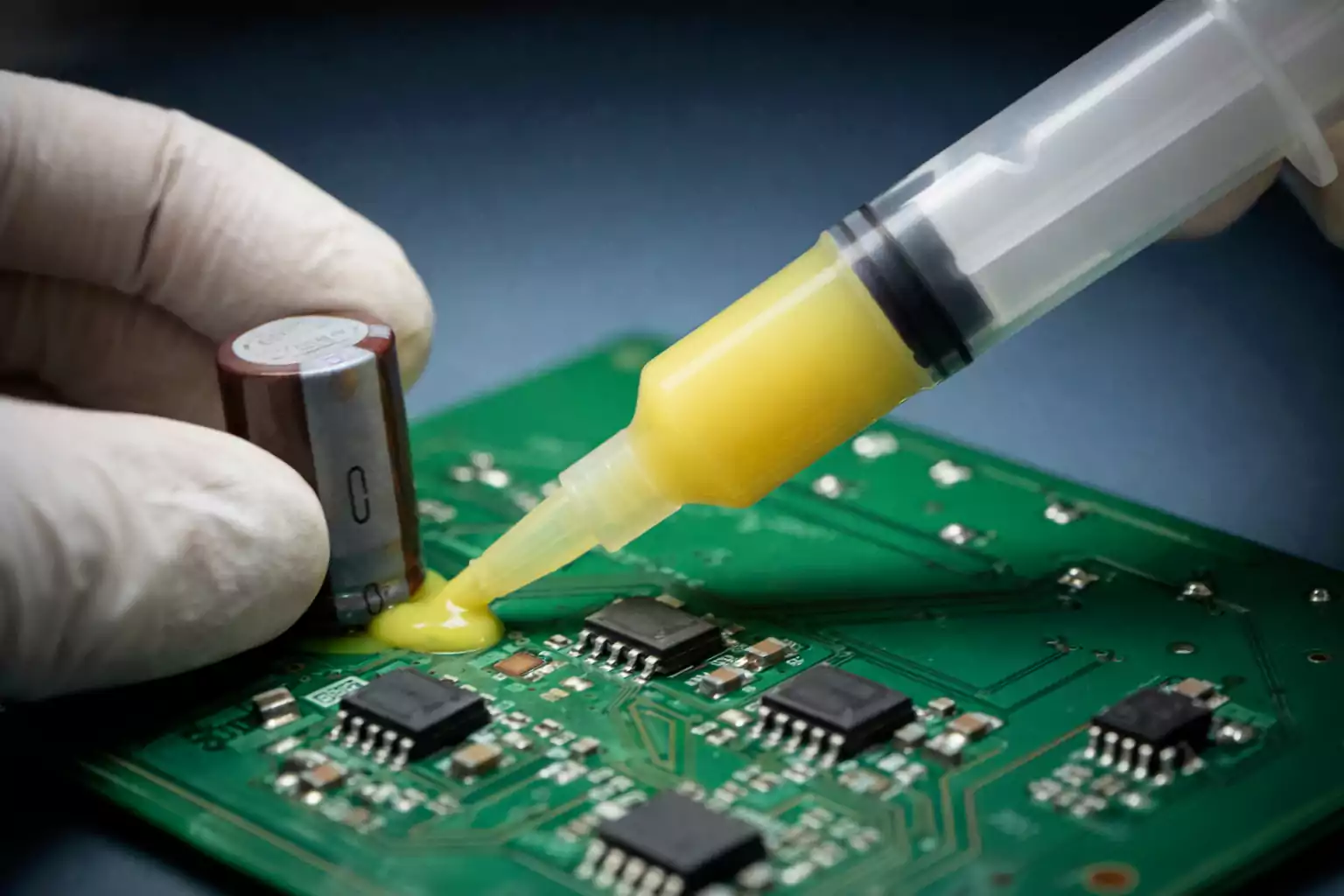 PCB adhesive applied to a capacitor on a circuit board